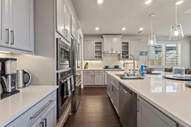 a dining room with stainless steel appliances kitchen island granite countertop a table and chairs