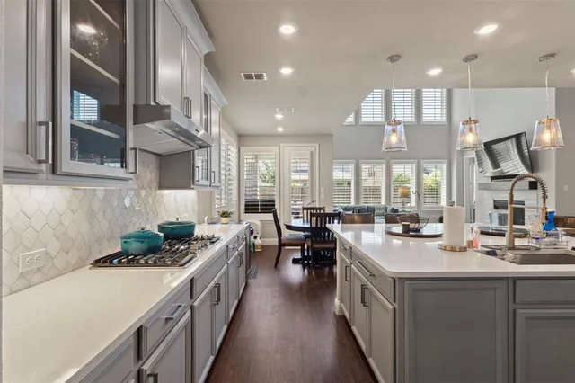 a kitchen with kitchen island granite countertop a sink stove and cabinets