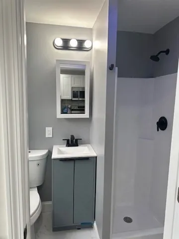 a bathroom with a toilet sink and mirror