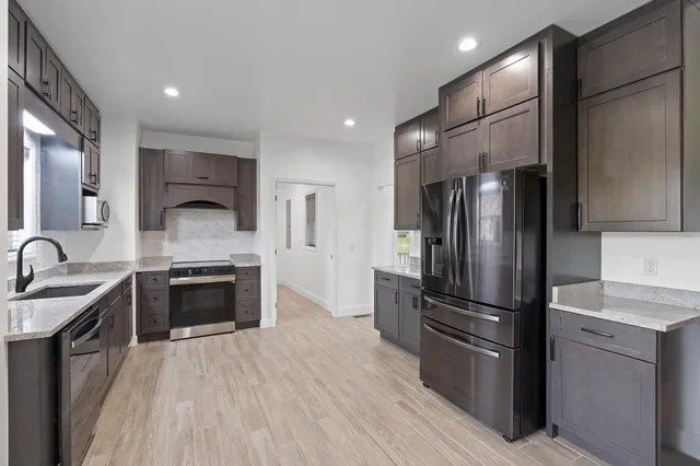 a kitchen with stainless steel appliances a refrigerator sink and stove
