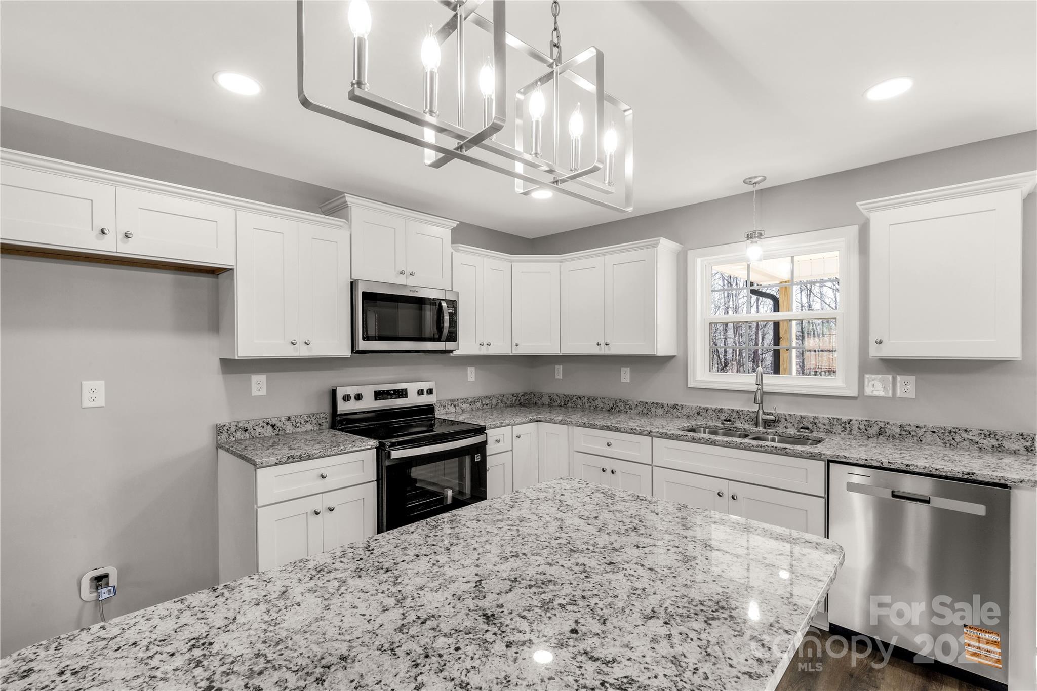 970 Helms Street Rock Hill, SC 29732 - Photo 21 of 32 a kitchen with stainless steel appliances granite countertop a sink a stove top oven a counter space and cabinets