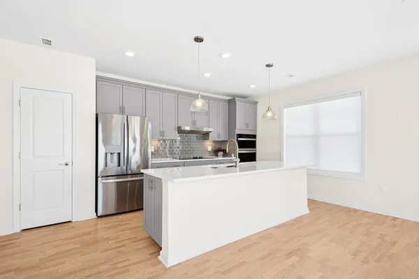 a kitchen with stainless steel appliances a refrigerator and a stove top oven