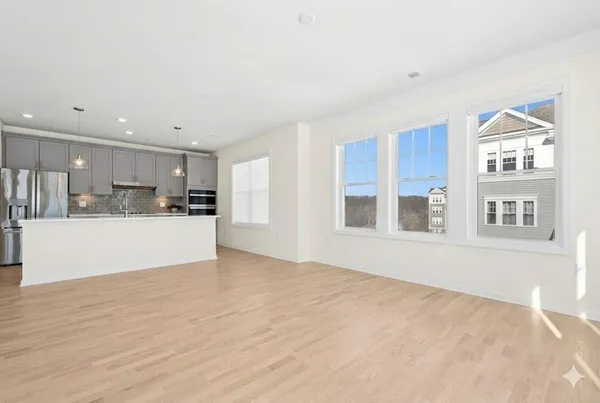 a view of a kitchen with kitchen island a sink wooden floor and a refrigerator