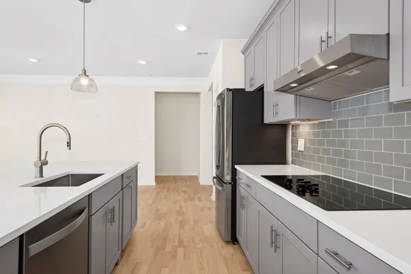 a kitchen with stainless steel appliances a sink a stove and a refrigerator with wooden floor