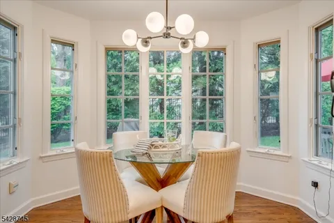 a view of a dining room with furniture a chandelier and wooden floor