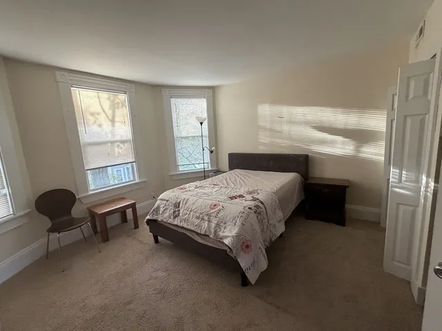 a bedroom with a bed chair and window