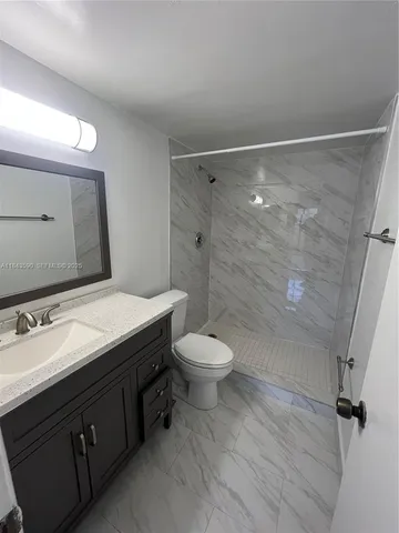 a white toilet sitting next to a bath tub and a shower