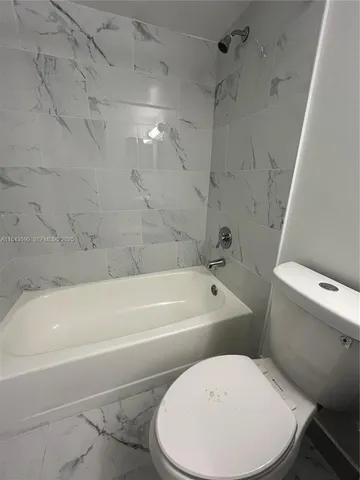 a white toilet sitting next to a bathroom sink and a mirror
