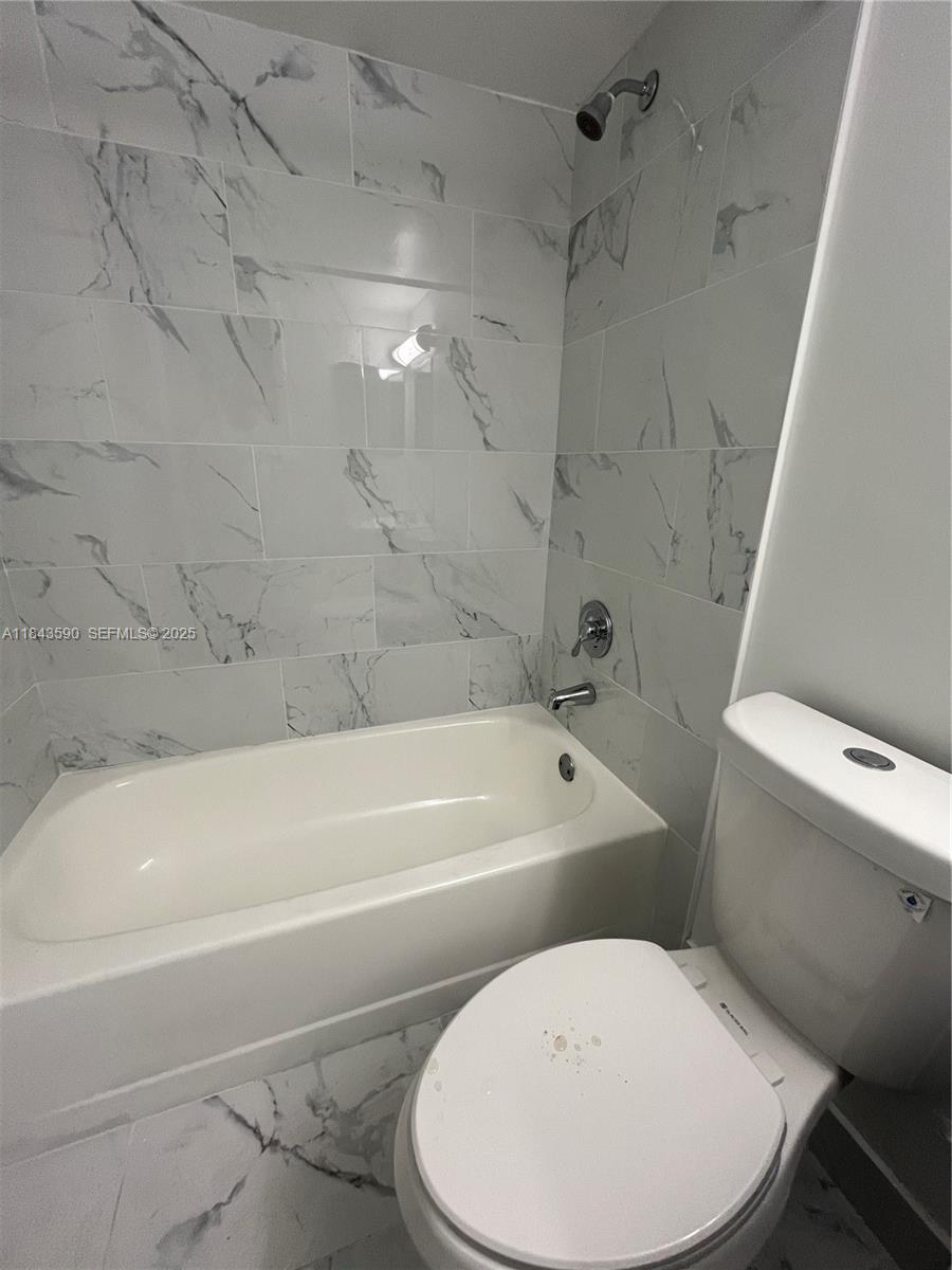 7430 Southwest 153rd Place, Unit 1061 Miami, FL 33193 - Photo 2 of 42 a white toilet sitting next to a bath tub and a shower