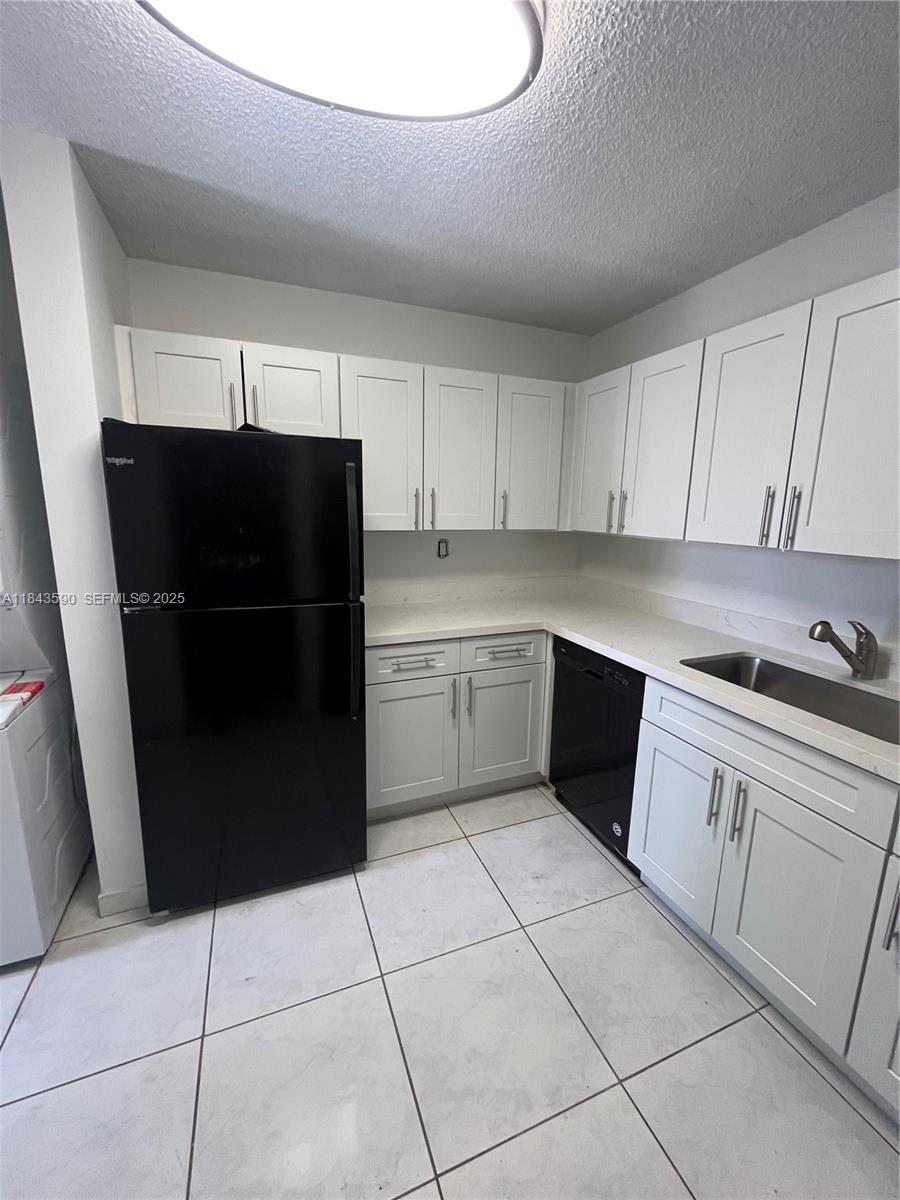 7430 Southwest 153rd Place, Unit 1061 Miami, FL 33193 - Photo 35 of 42 a kitchen with a refrigerator a stove and cabinets