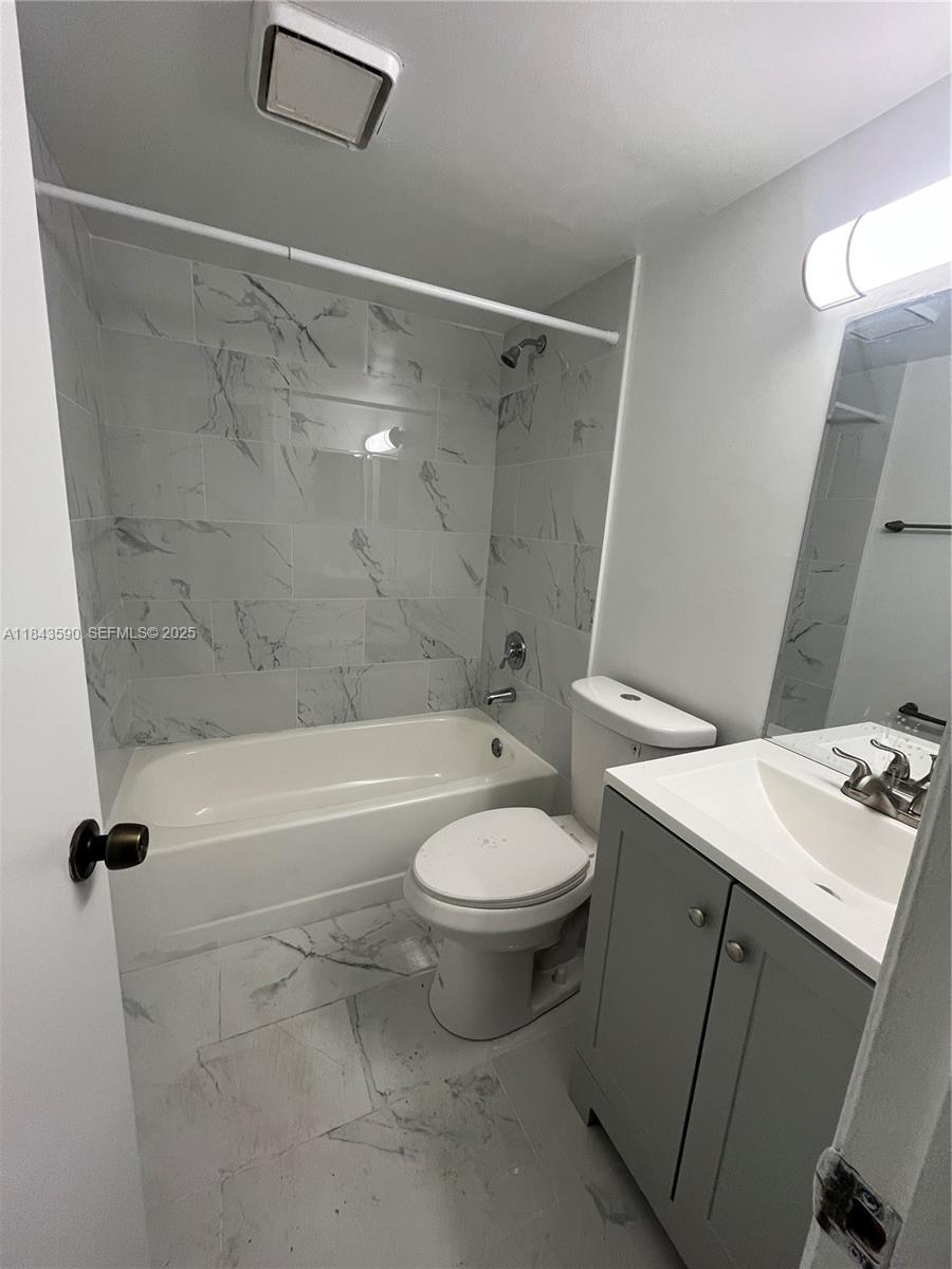 7430 Southwest 153rd Place, Unit 1061 Miami, FL 33193 - Photo 9 of 42 a bathroom with a granite countertop sink toilet and shower
