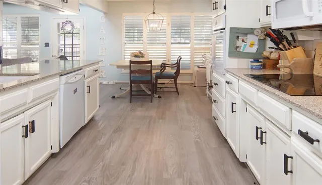 a kitchen with granite countertop white cabinets and white appliances