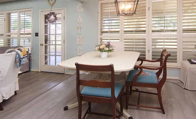 a kitchen with stainless steel appliances wooden floors and white cabinets