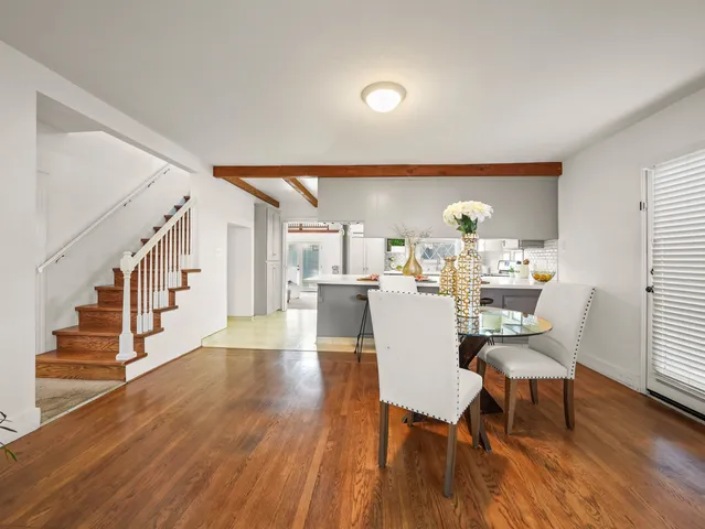 a view of a dining room with furniture a rug and wooden floor