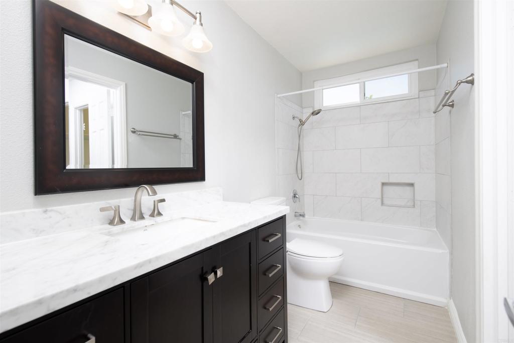 4215 Cielo Avenue Oceanside, CA 92056 - Photo 22 of 27 a bathroom with a double vanity sink toilet mirror and bathtub