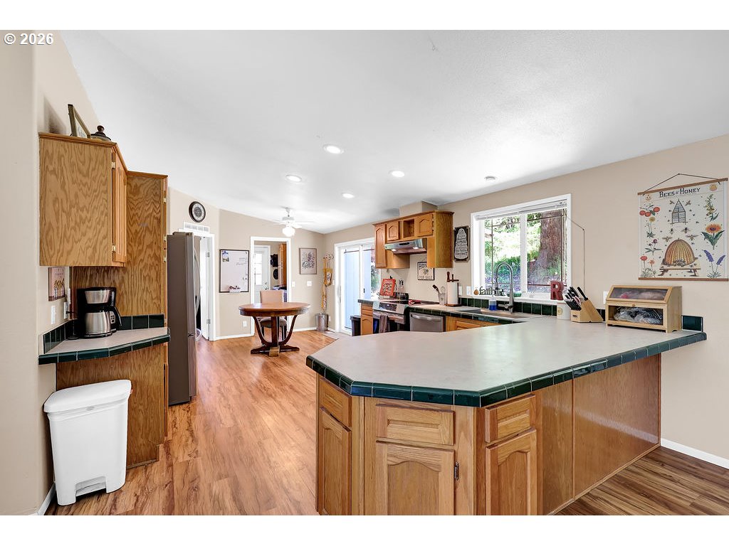 35235 Row River Road Cottage Grove, OR 97424 - Photo 16 of 28 a room with stainless steel appliances wooden floor dining table and chairs