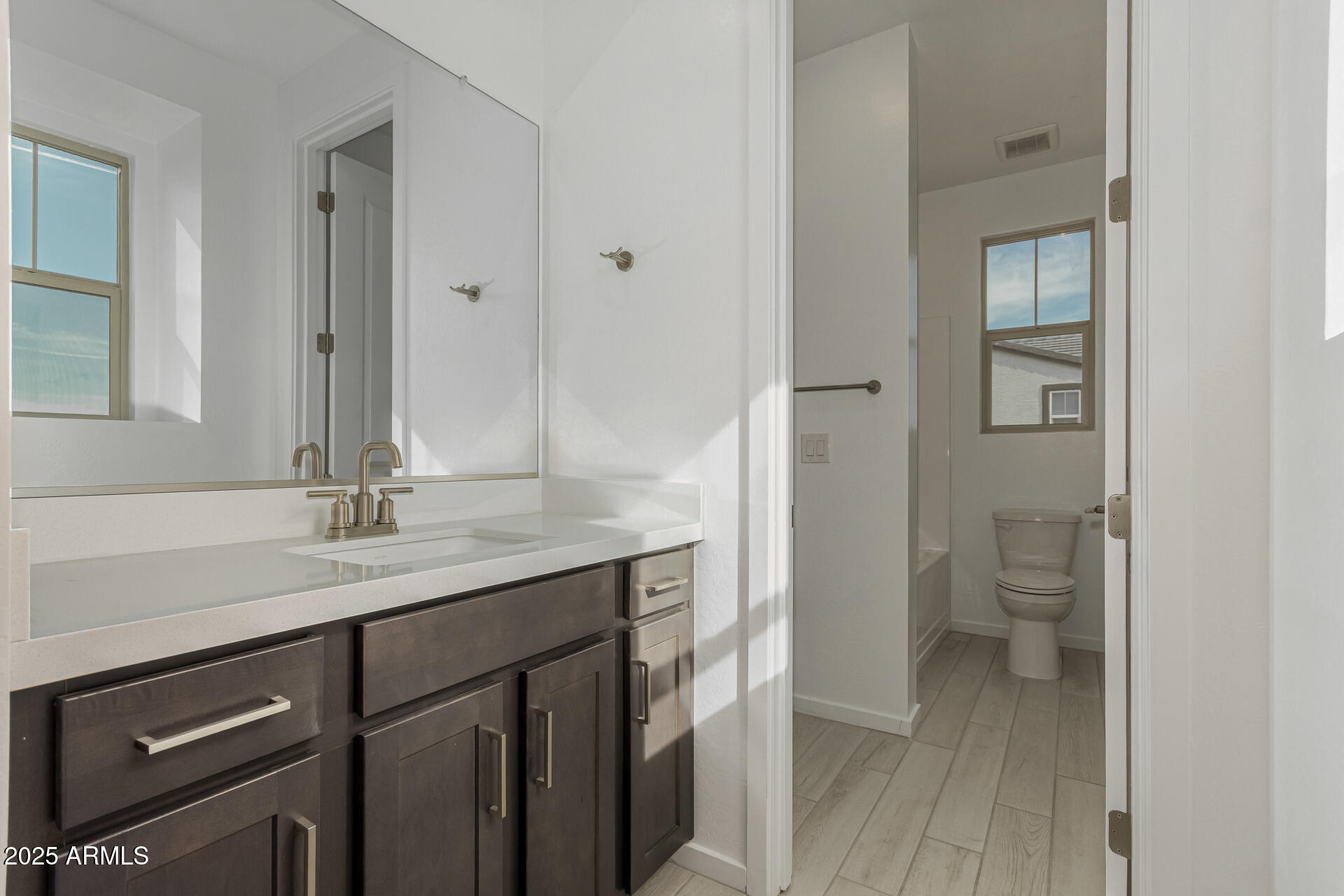 2474 West Rowel Road Phoenix, AZ 85085 - Photo 24 of 38 a bathroom with a granite countertop sink a toilet and a mirror