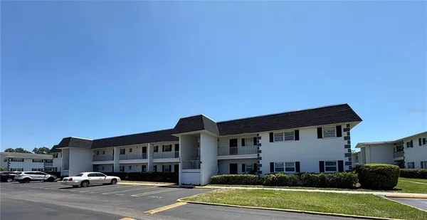 a front view of a building with cars parked