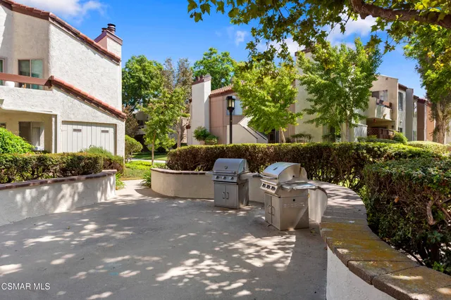 a view of a swimming pool with lawn chairs under an umbrella