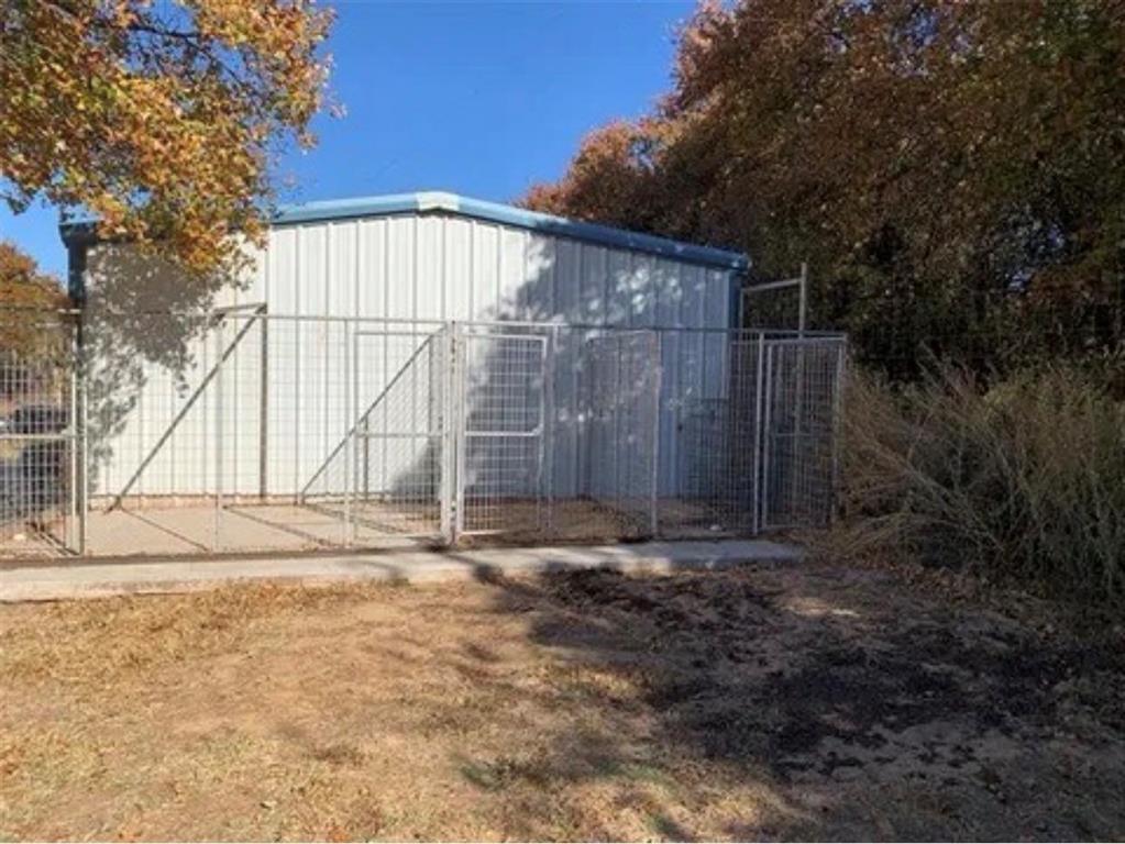 1794 Cr 527 Road Baird, TX 79504 - Photo 6 of 38 Metal utility building with a blue trim roof and surrounding chain-link fencing
