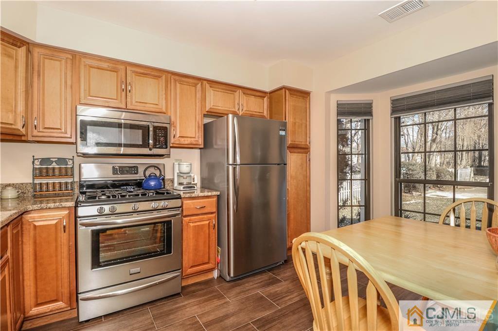 306 Maplecrest Road, Unit 306 Edison, NJ 08820 - Photo 5 of 25 a kitchen with stainless steel appliances wooden floor sink stove and refrigerator