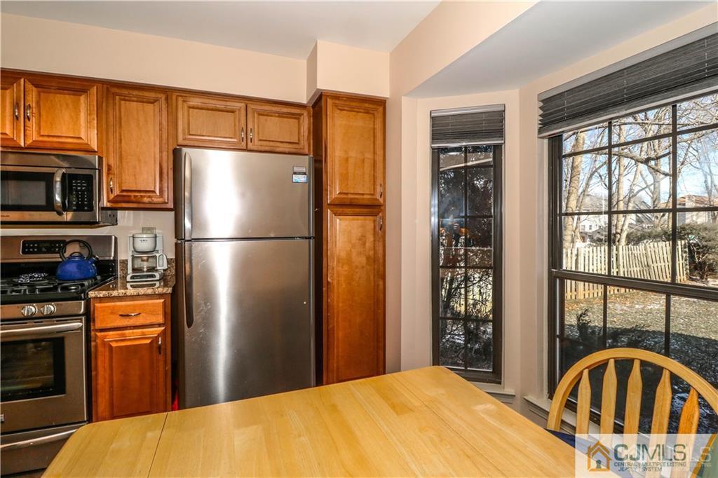 306 Maplecrest Road, Unit 306 Edison, NJ 08820 - Photo 6 of 25 a kitchen with stainless steel appliances granite countertop a refrigerator a stove top oven a refrigerator a sink and dishwasher a refrigerator with wooden floor