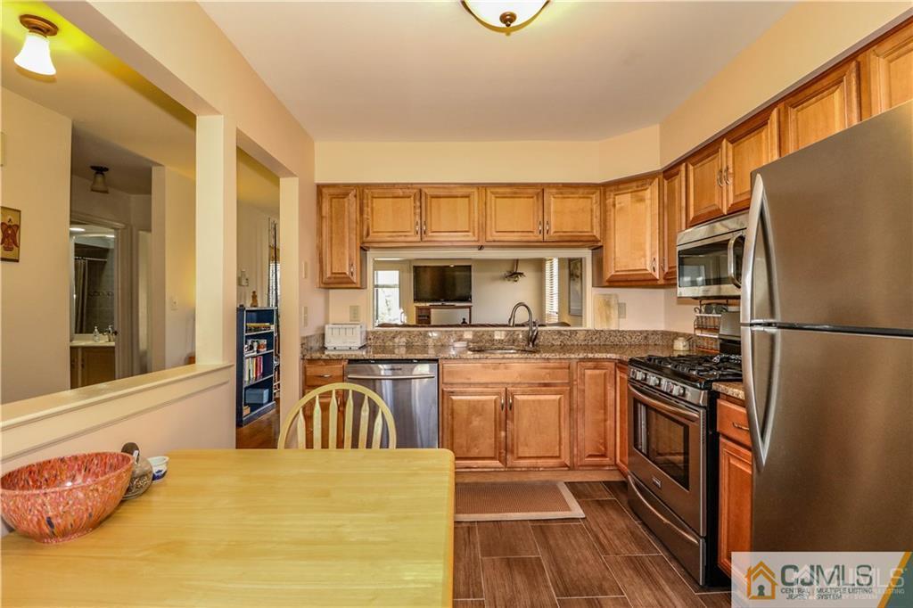306 Maplecrest Road, Unit 306 Edison, NJ 08820 - Photo 7 of 25 a kitchen with stainless steel appliances granite countertop a sink stove and refrigerator