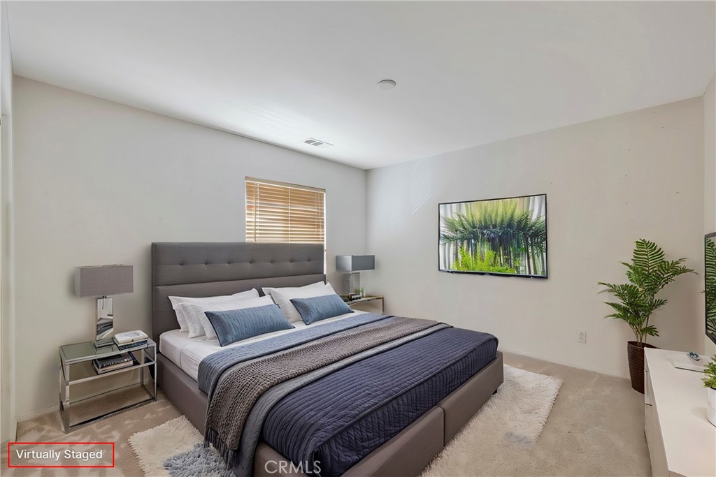 3819 St Austell Way Perris, CA 92571 - Photo 36 of 64 a bedroom with a bed and a potted plant