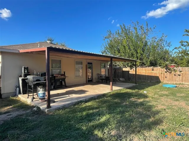 a backyard of a house with table and chairs