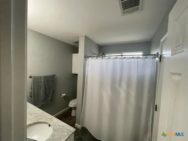 a bathroom with a shower curtain and a toilet