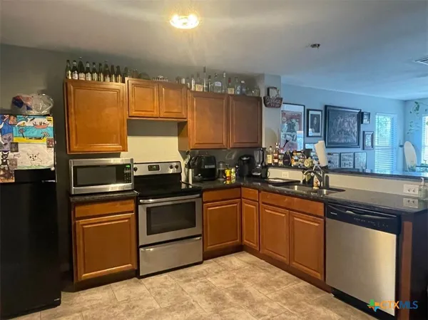 a kitchen with granite countertop stainless steel appliances and sink