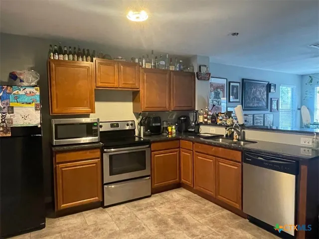 a kitchen with granite countertop stainless steel appliances and sink