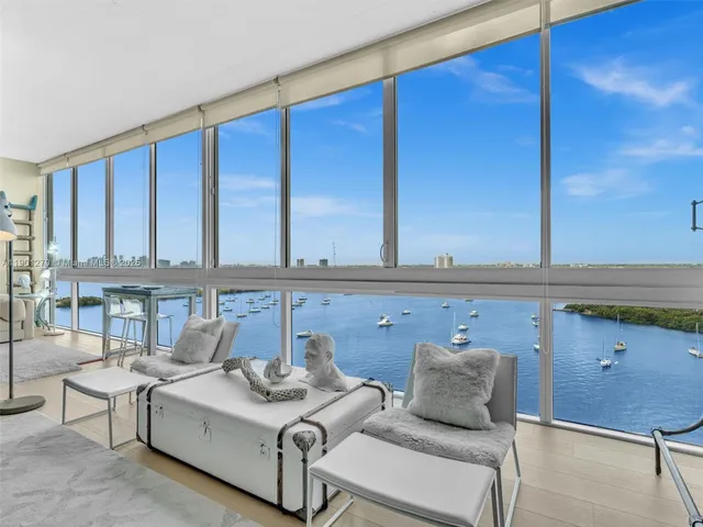 a living room with furniture and floor to ceiling windows