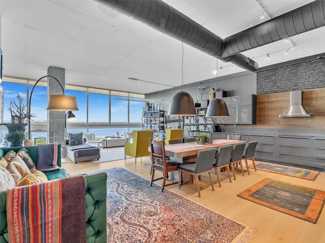 a kitchen with stainless steel appliances kitchen island granite countertop a table and chairs in it