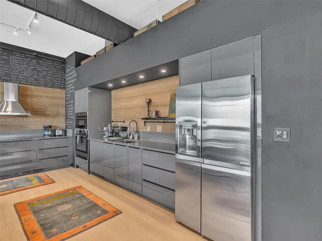 a kitchen with stainless steel appliances granite countertop a table chairs sink and cabinets