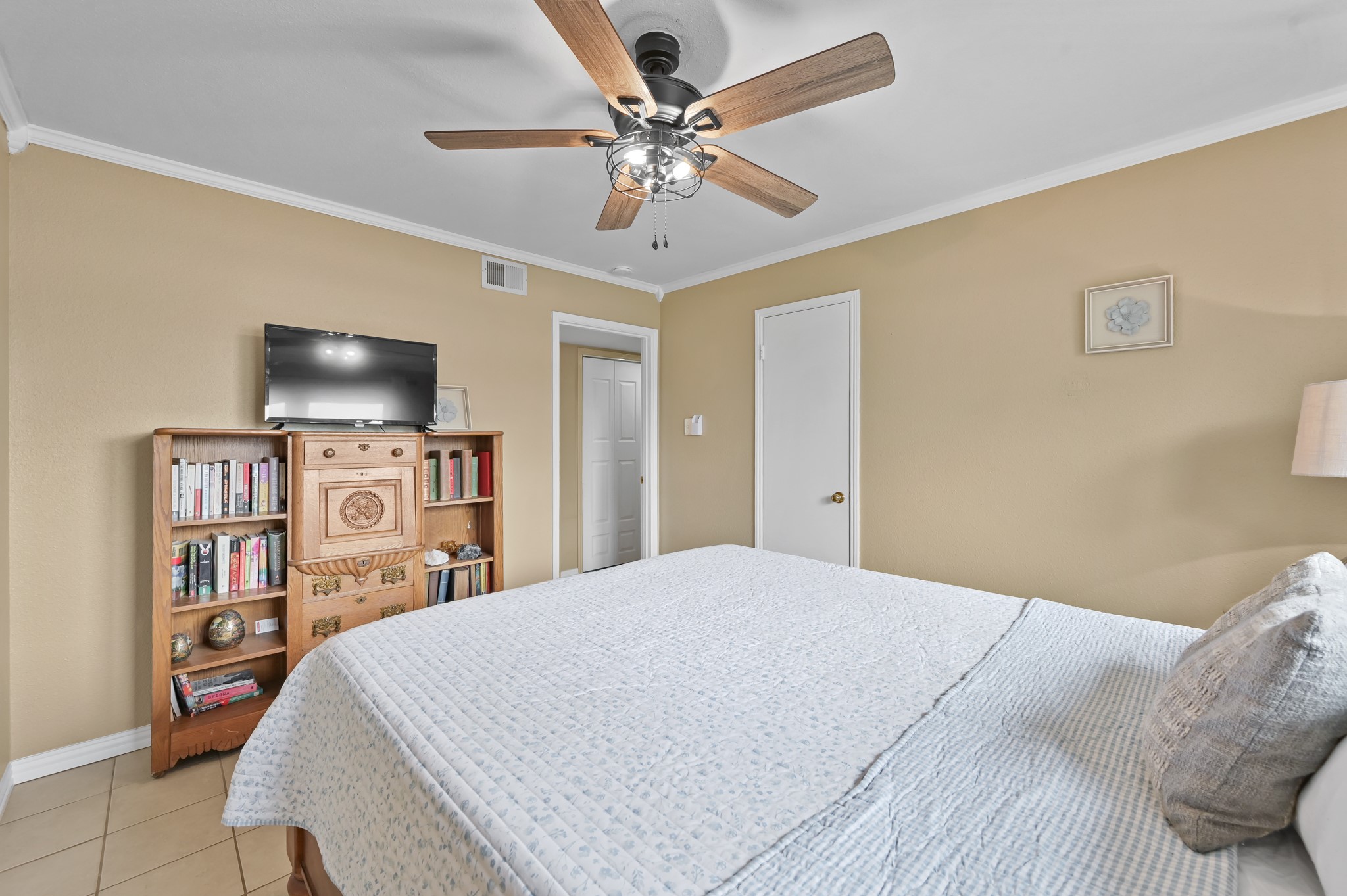 116 April Point Drive North Conroe, TX 77356 - Photo 13 of 44 a bedroom with a bed a flat screen tv and a chandelier