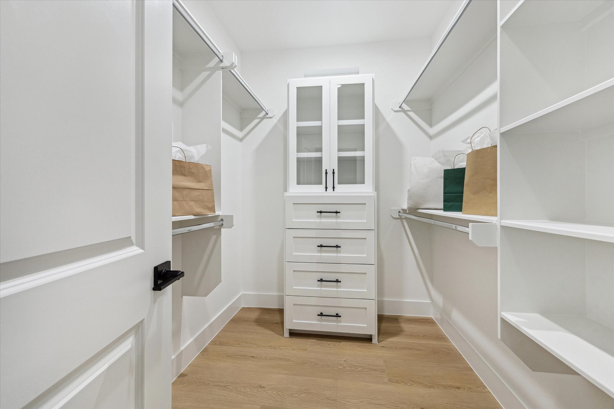 752 Curtin Street Houston, TX 77018 - Photo 33 of 37 Spacious walk-in closet featuring built-in shelving, ample hanging space, and a central cabinet with drawers for organized storage.