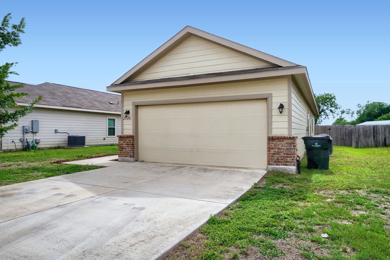 2420 Ranger Pass Seguin, TX 78155 - Photo 2 of 28 Front exterior featuring a two-car garage with overhead door, brick accent skirting, and dual exterior wall lanterns