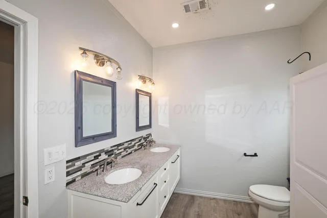 a bathroom with a sink vanity mirror and toilet