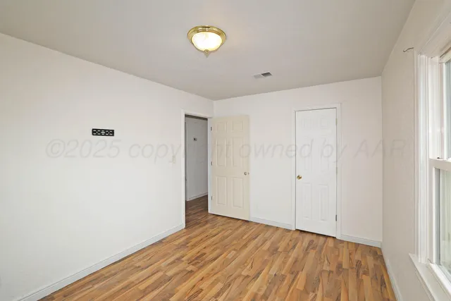 a view of a room with wooden floor and white walls