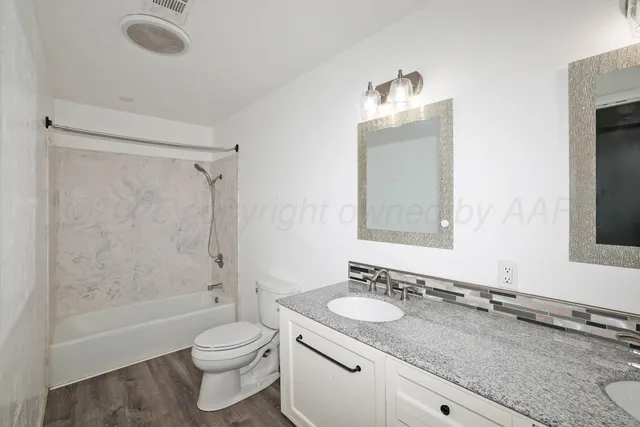 a bathroom with a granite countertop sink toilet and shower