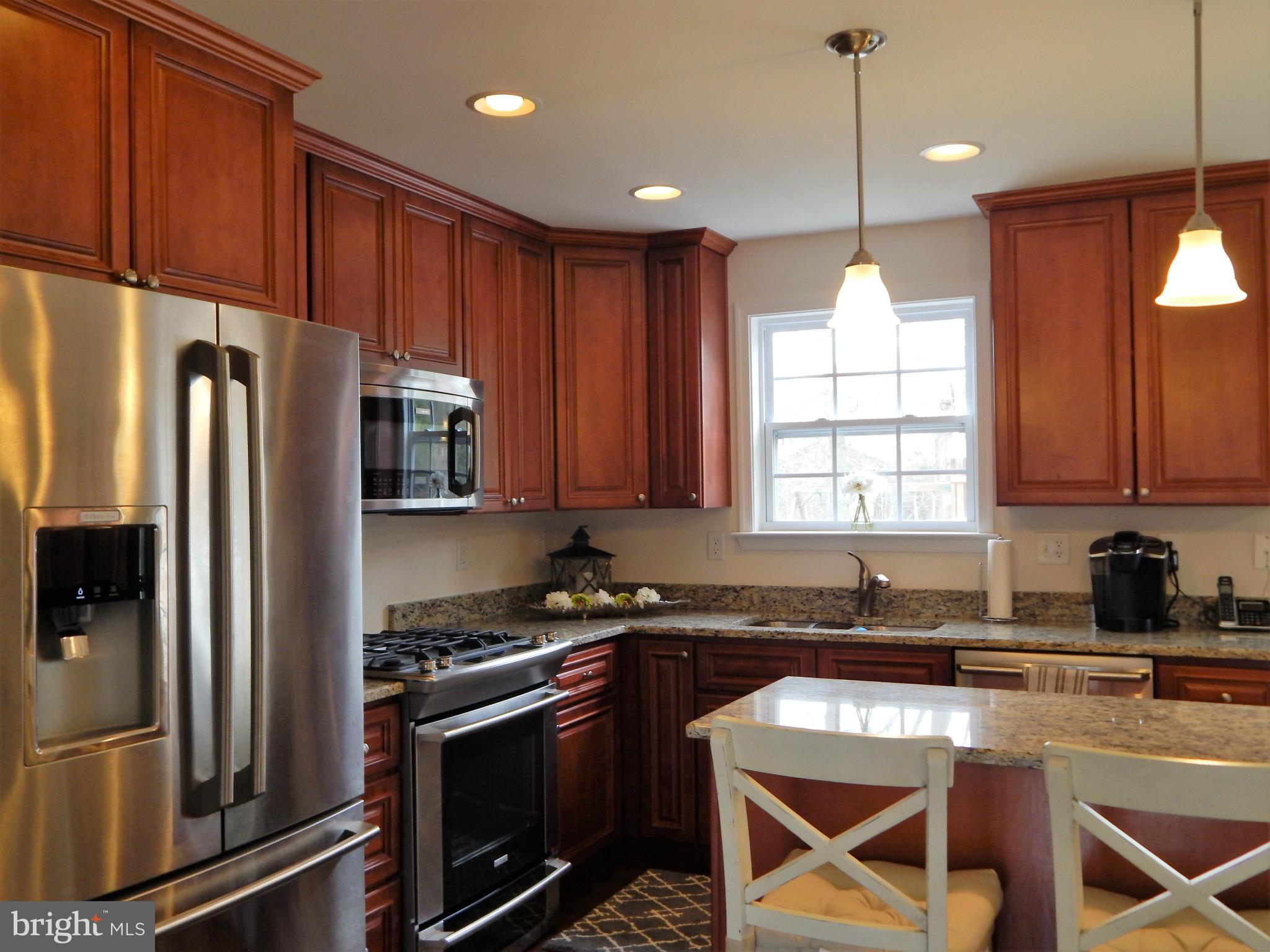 8254 Quarterfield Road Severn, MD 21144 - Photo 11 of 30 a kitchen with stainless steel appliances granite countertop a refrigerator a sink dishwasher a stove and a microwave