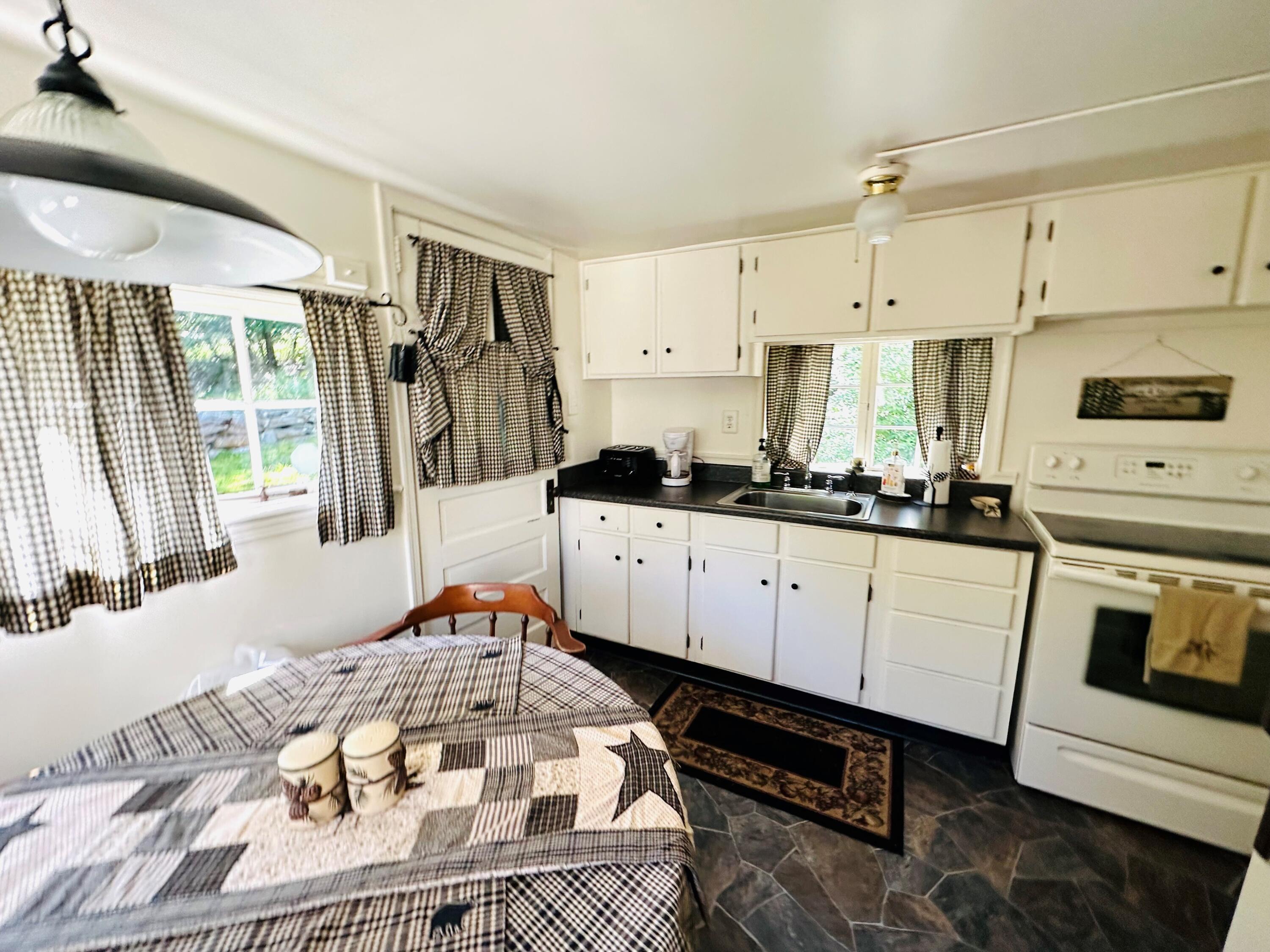 139 Pecks Pond Road Dingmans Ferry, PA 18328 - Photo 9 of 26 a kitchen with stainless steel appliances a stove a sink and white cabinets