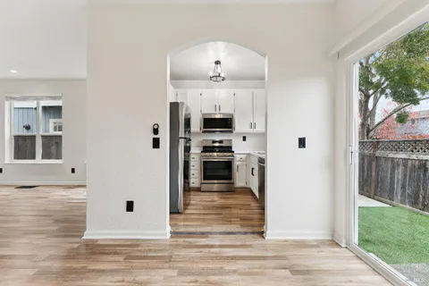 a view of a kitchen with wooden floor and a fireplace