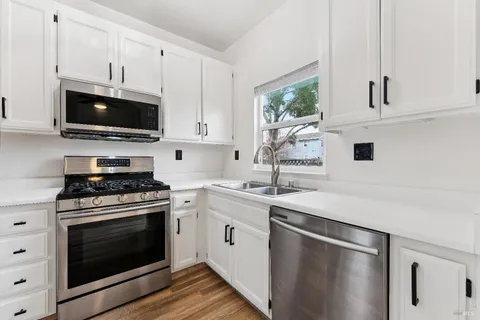 a kitchen with cabinets stainless steel appliances a sink and a stove