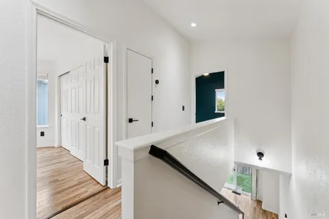a view of a hallway with wooden floor and staircase