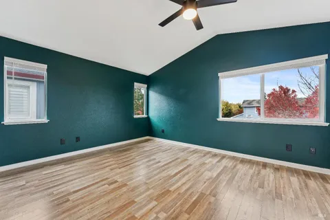 a view of a room with wooden floor and fan