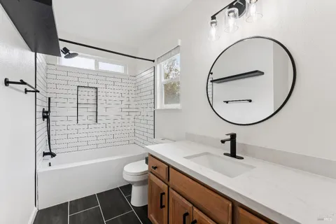 a bathroom with a sink a toilet and a mirror