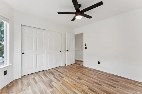 a view of a livingroom with wooden floor and a ceiling fan