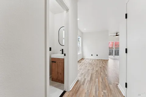 a view of a hallway with wooden floor and staircase